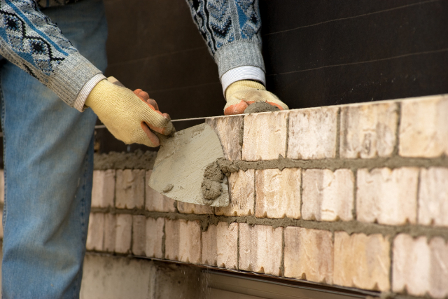 Worker building brick wall